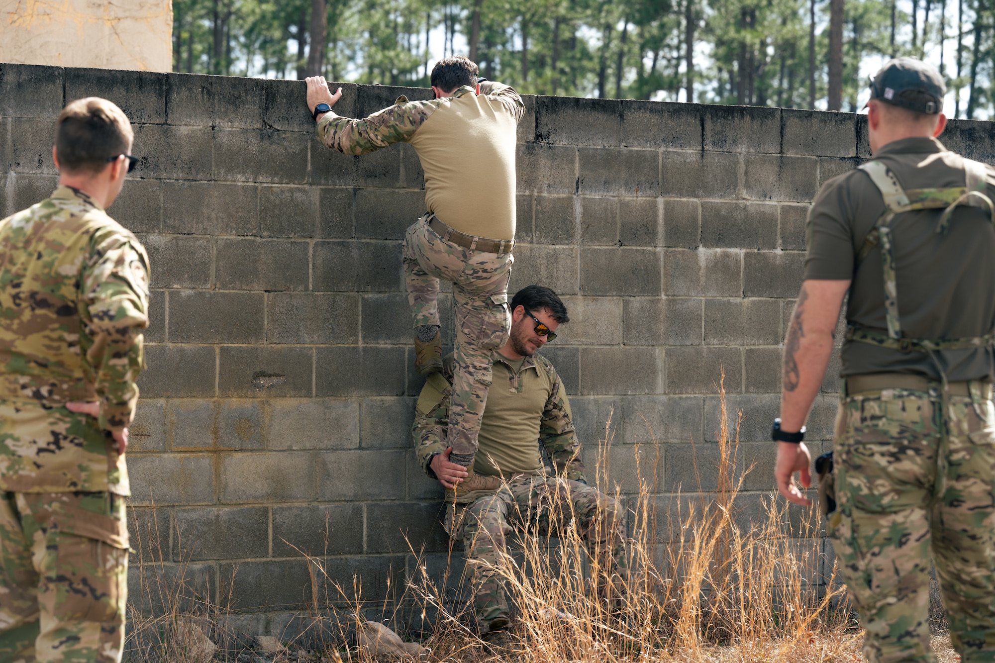 U.S. Air Force Air Commandos climb a wall during a survival, escape, resistance, and evasion training at the Eglin Range, Florida, Feb. 8, 2024.