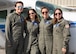Four female pilots wearing sunglasses stand in front of a small plane.