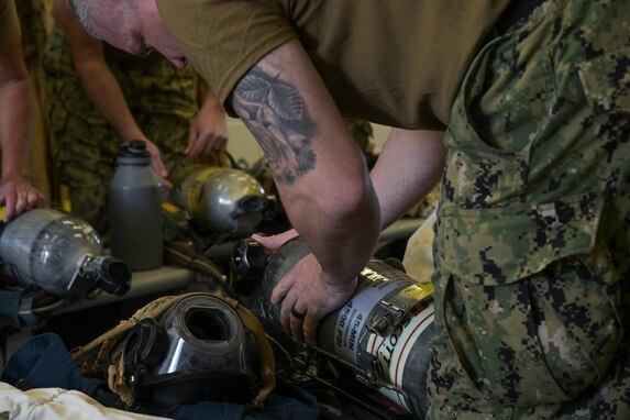 Sailors put on self-contained breathing apparatuses during training to manage access control points at the Red Hill Bulk Fuel Storage Facility (RHBFSF), in preparation to transition responsibility for the facility from Joint Task Force -Red Hill (JTF-RH) to Navy Closure Task Force - Red Hill (NCTF-RH) at Joint Base Pearl Harbor - Hickam, Hawaii on Feb. 7, 2024.