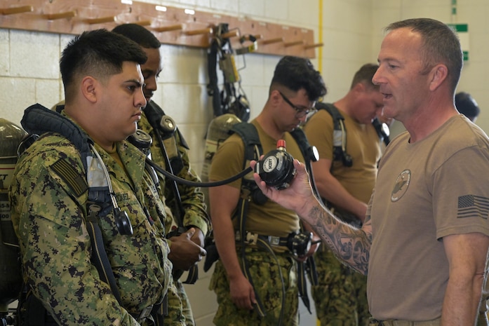 Sailors put on self-contained breathing apparatuses during training to manage access control points at the Red Hill Bulk Fuel Storage Facility (RHBFSF), in preparation to transition responsibility for the facility from Joint Task Force-Red Hill (JTF-RH) to Navy Closure Task Force - Red Hill (NCTF-RH) at Joint Base Pearl Harbor-Hickam, Hawaii on Feb. 7, 2024.