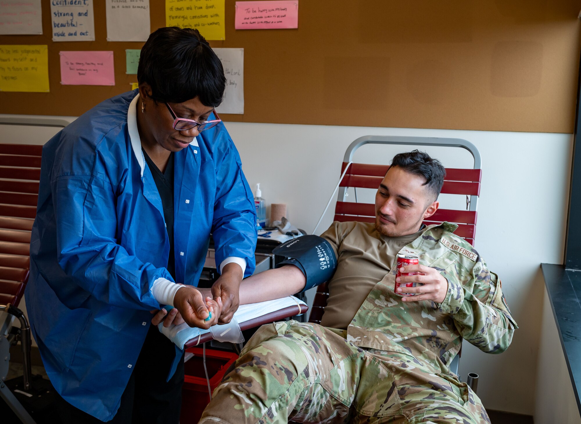 Paula Evans, left, Walter Reed National Military Medical Center phlebotomist, prepares medical tubing on the arm of U.S. Air Force Senior Airman Cameron Page, 512th Aircraft Maintenance Squadron electrical and environmental technician, before donating blood at Dover Air Force Base, Delaware, Dec. 6, 2022. Team Dover collectively donated 31 units of blood during the drive which has the potential to save 63 lives.  (U.S. Air Force photo by Airman 1st Class Amanda Jett)