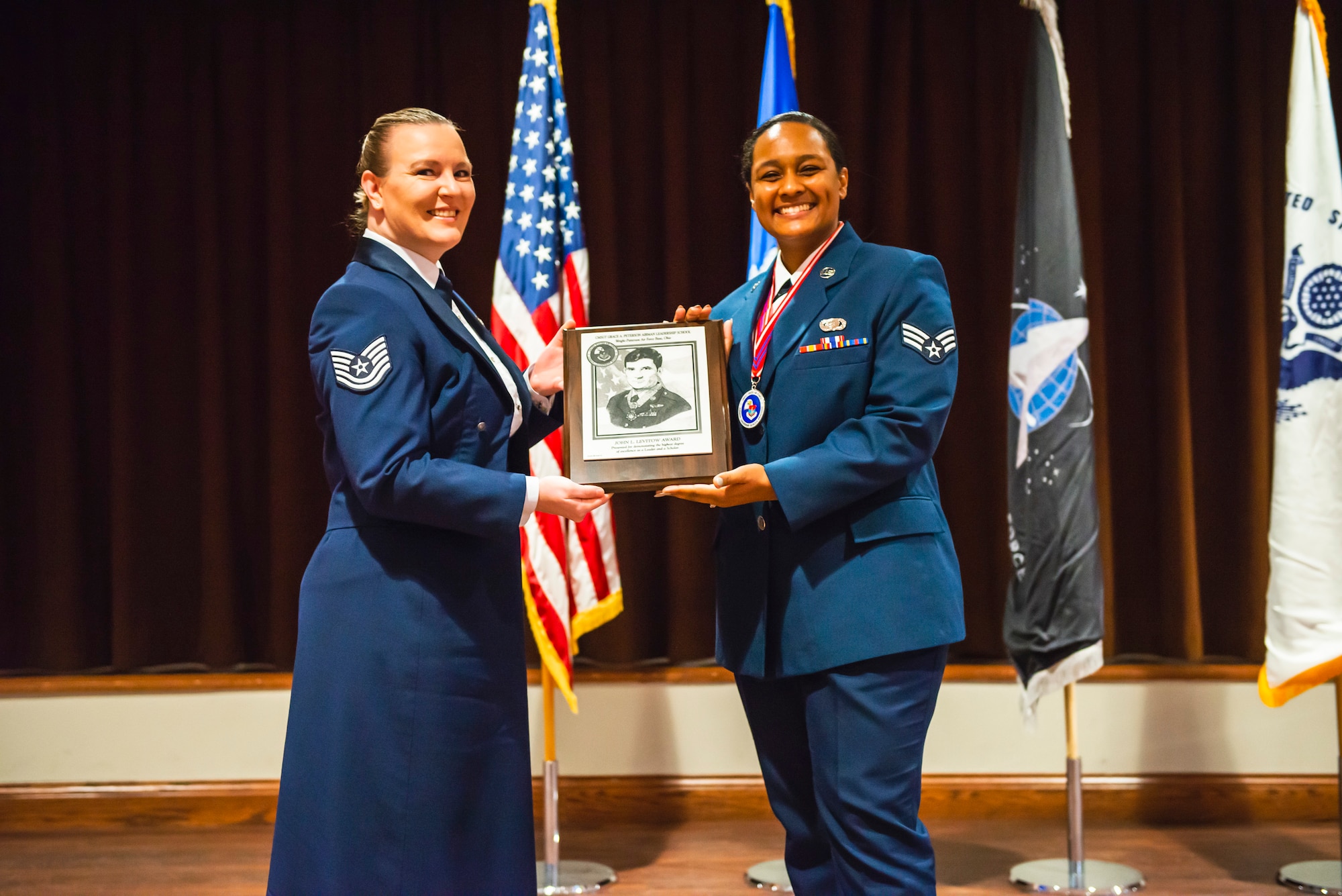 Airmen pose holding an award