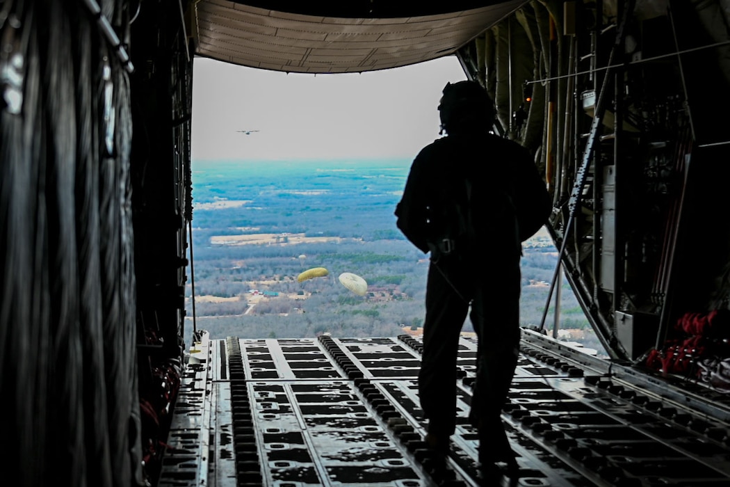 An Airman walks to the back of a flying C-130J Super Hercules aircraft