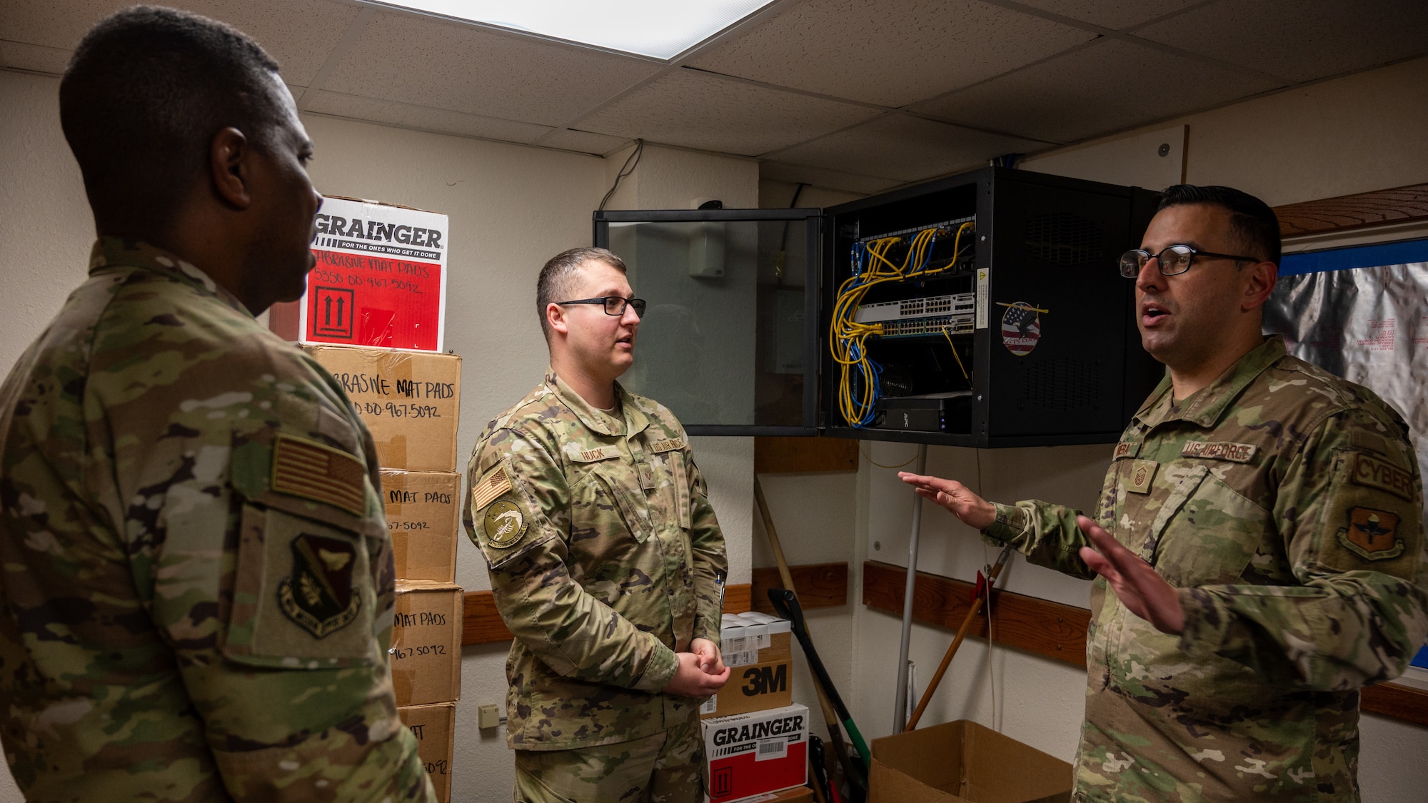 U.S. Air Force Master Sgt. David Herrera (right), 47th Communications Squadron (CS) network control center section chief, Senior Airmen Jerremy Huck (center), 47th CS technician, explains to Col. Robert Moore (left), 47th Mission Support Group (MSG) commander, the installation process of a new switch at Laughlin Air Force Base, Texas, Feb. 6, 2024.(U.S. Air Force photo by Staff Sgt. Nicholas Larsen)