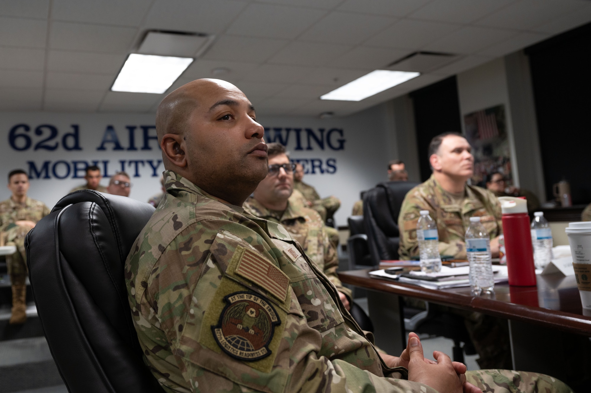 U.S. Air Force Chief Master Sgt. Nahkoma Doyle, 627th Logistics Readiness Squadron senior enlisted leader, listens to a presentation on security forces protocol during a three-day tabletop exercise at Joint Base Lewis-McChord, Washington, Feb. 8, 2024.