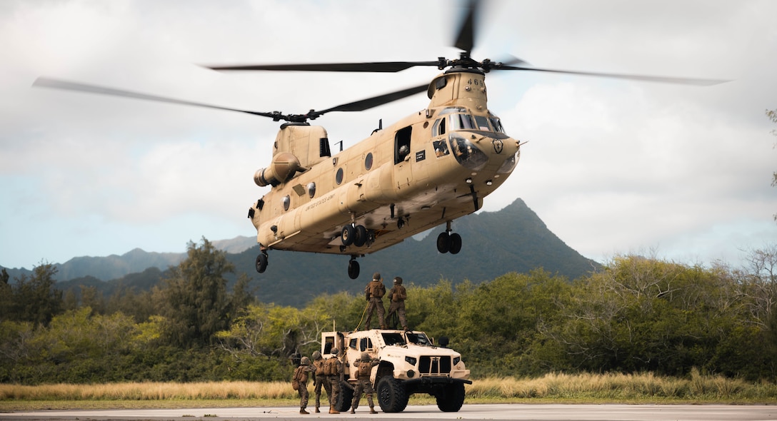 U.S. Marines with 3d Littoral Logistics Battalion, 3d Marine Littoral Regiment, 3d Marine Division, hooks a Joint Light Tactical Vehicle onto a Army CH-47 Chinook during the 3d Littoral Logistics Battalion’s Helicopter Support Team training at Marine Corps Training Area Bellows, Hawaii, Feb. 2, 2024. The 3d LLB undergoes transportation training under the pressure of a tactical scenario in order to prepare realistically for future operations. (U.S. Marine Corps photo by Cpl. Eric Huynh)