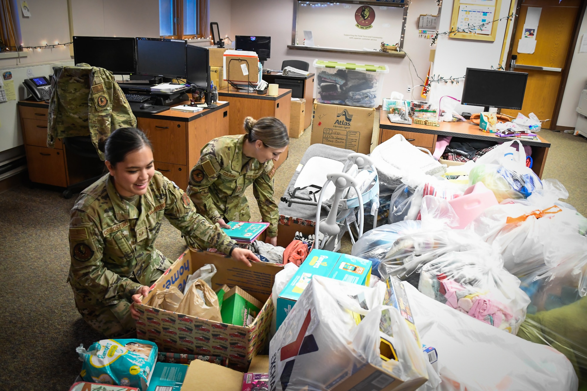 Staff Sgt. Amberylynn Cristostomo left, and Tech Sgt. Tiffany Colburn of the 168th Force Support Squadron organize donations and gifts for the Nonprofit Interior Alaska Center for Non-Violent Living.