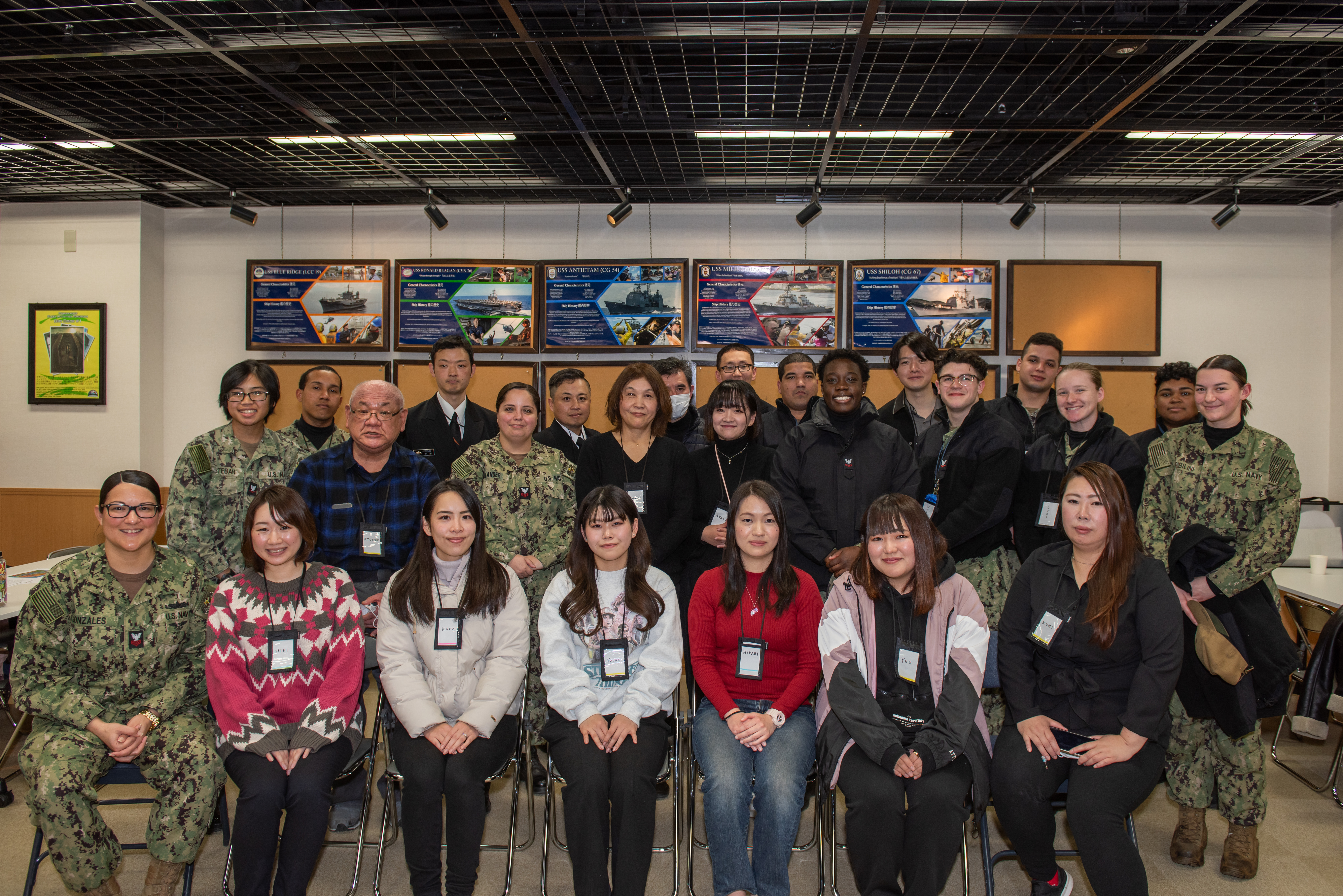 A group shot of Sailors and Japanese community members at the Yokosuka Navy Awesome Cafe.