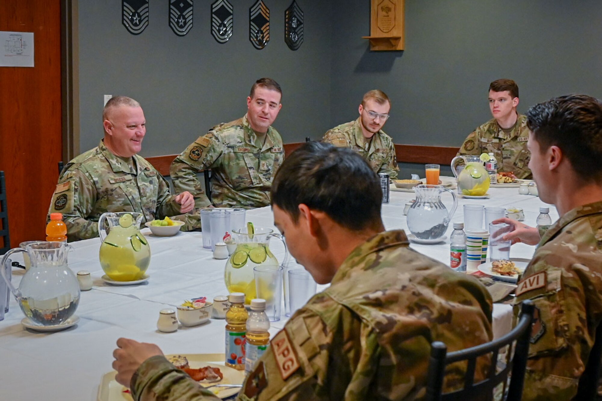 Six Airman sit around a white table