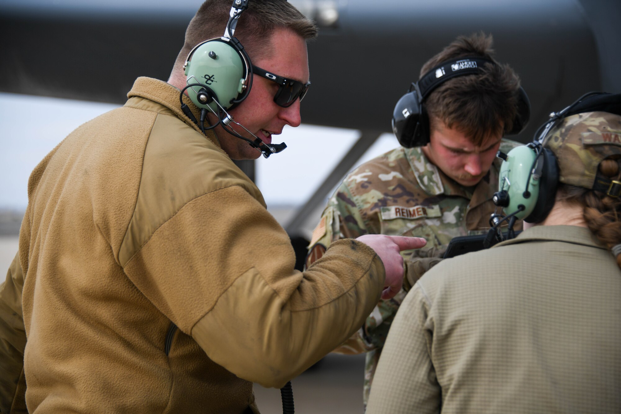 U.S. Air Force Tech. Sgt. Austin Shackelford, 190th Aircraft Maintenance Squadron (AMXS) crew chief, speaks to Staff Sgt. Karson Reimer and Senior Airman Allison Walania, 190th AMXS crew chiefs, during a hot pit refueling training at Altus Air Force Base (AFB), Oklahoma, Feb. 6, 2024. 190th Air Refueling Wing members teamed up with Airmen from the 97th Aircraft Maintenance Squadron, 97th Logistics Readiness Squadron, and 54th Air Refueling Squadron to conduct the first ever hot pit refueling training at Altus AFB. (U.S. Air Force photo by Senior Airman Miyah Gray)