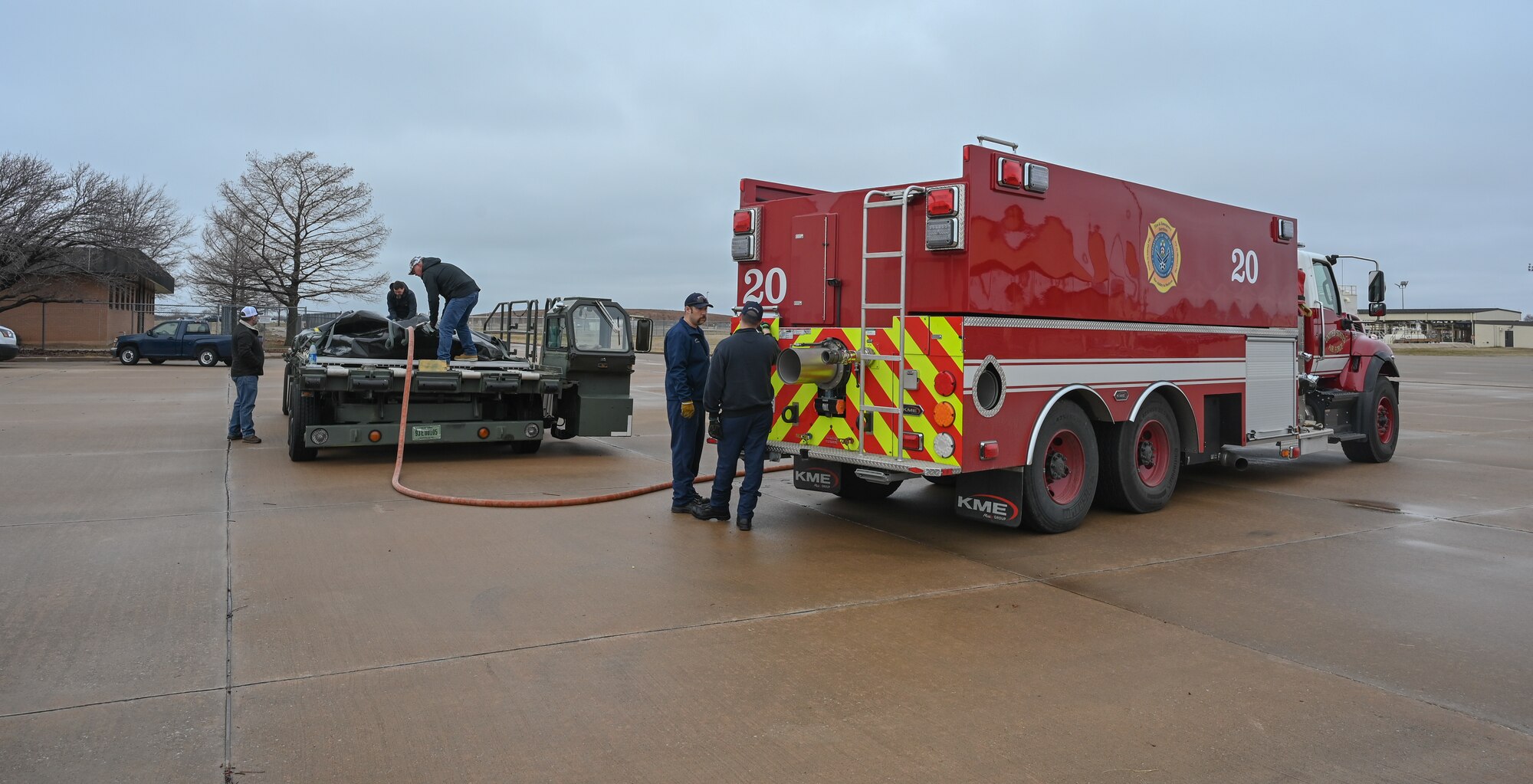 A firetruck pumps water into a fuel bladder