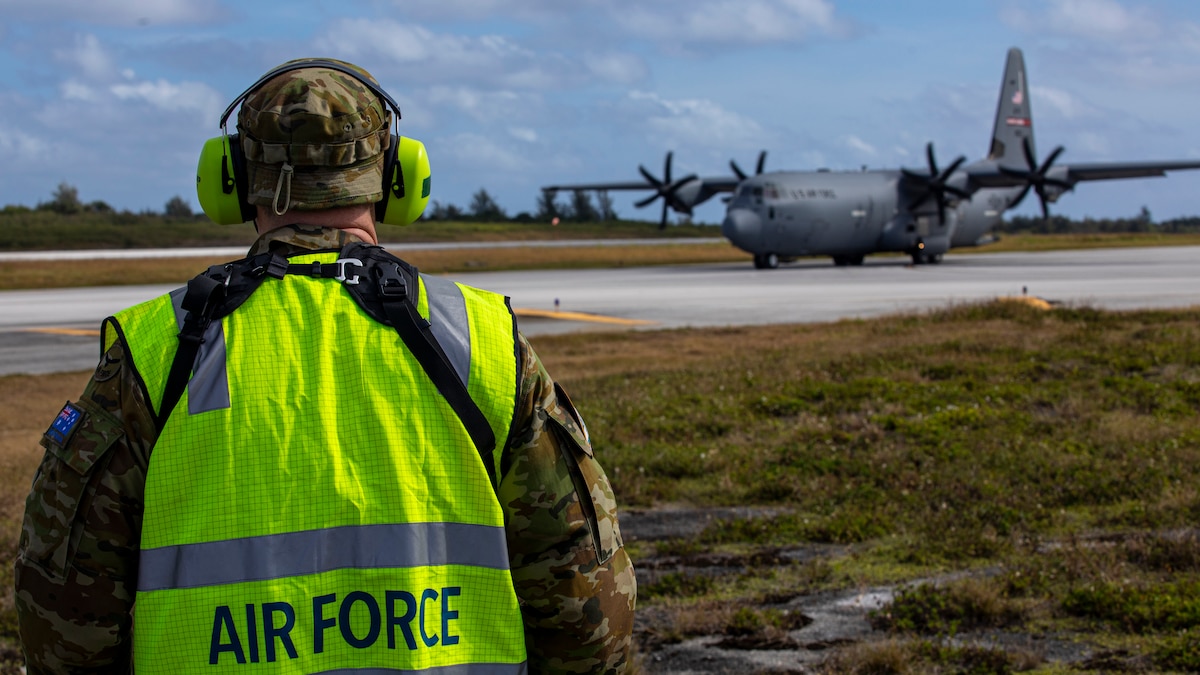 Royal Australian Air Force specialist watches as a U.S. Air Force C-130J Super Hercules aircraft taxis the flight line during Cope North 24.