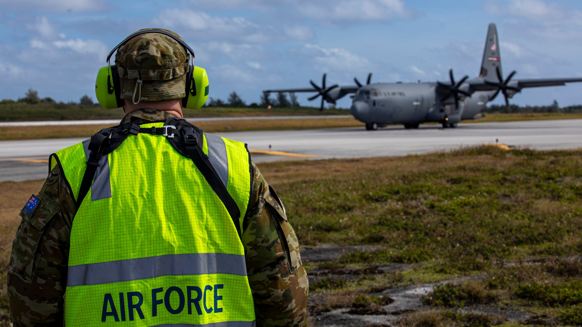 Royal Australian Air Force specialist watches as a U.S. Air Force C-130J Super Hercules aircraft taxis the flight line during Cope North 24.
