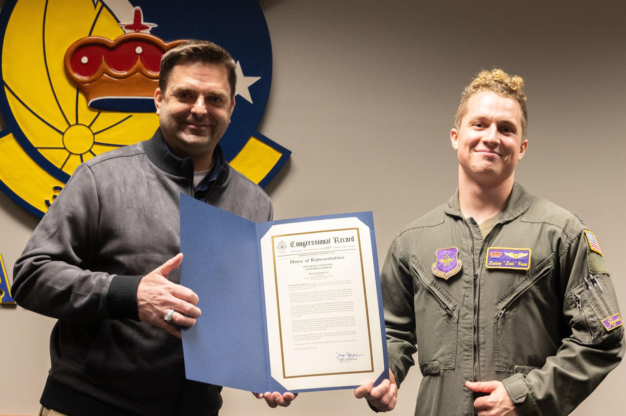 U.S. Air Force Capt. Zachary Evans, right, 3rd Airlift Squadron pilot, receives a congressional award from Mark Dreling, left, Office of Congressman Don Bacon chief of staff at Dover Air Force Base, Delaware, Feb. 9, 2024. Evans was honored for rescuing a man from a burning vehicle, who had broken both legs in the accident. (U.S. Air Force photo by Airman 1st Class Dieondiere Jefferies)