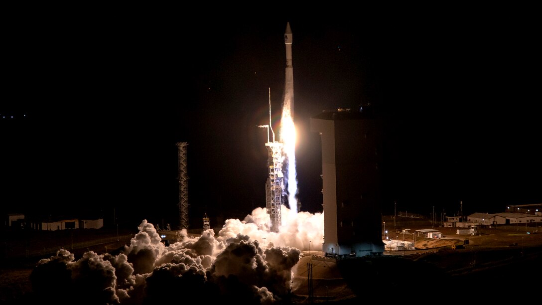 Smoke plumes from the base of a rocket as it gets ready to launch at night.
