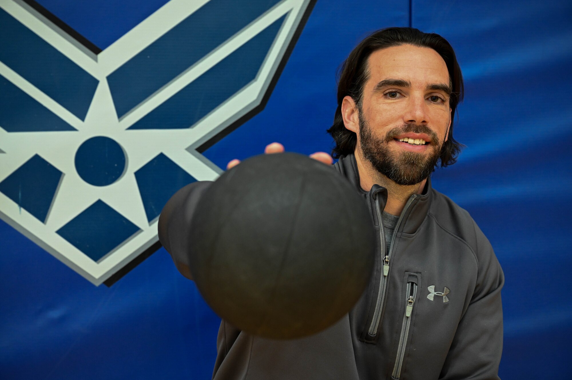 Luke Christy, Health and Fitness Program Manager assigned to the 910th Force Support Squadron, poses for a feature photo while holding a weight ball at the fitness center, Feb. 13, 2024, at Youngstown Air Reserve Station, Ohio.