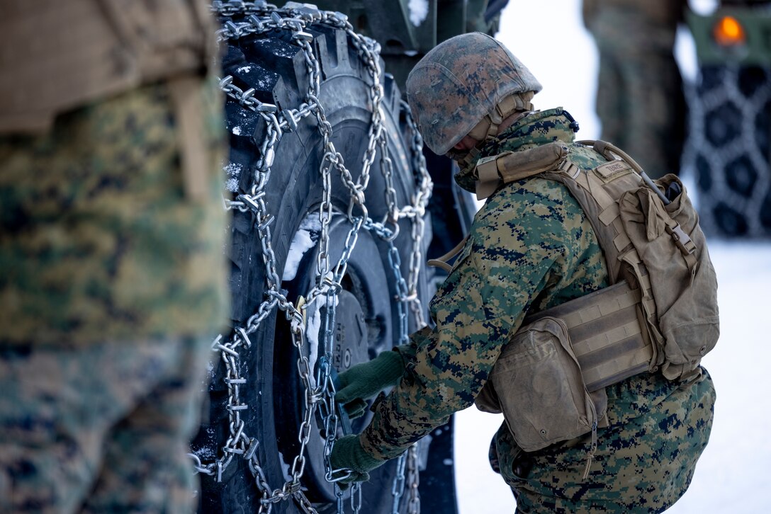 U.S. Marine Corps Sgt. Ryan Tegze, a Texas native and a motor transport operator with Marine Wing Support Squadron (MWSS) 273, 2nd Marine Aircraft Wing, attaches snow chains to the wheel of a medium tactical-vehicle replacement during a slippery-road training course in preparation for Exercise Nordic Response 24 at Setermoen, Norway, Feb. 8, 2024. Exercise Nordic Response, formerly known as Cold Response, is a NATO training event conducted every two years to promote military competency in arctic environments and to foster interoperability between the U.S. Marine Corps and allied nations. (U.S. Marine Corps photo by Cpl. Christopher Hernandez)