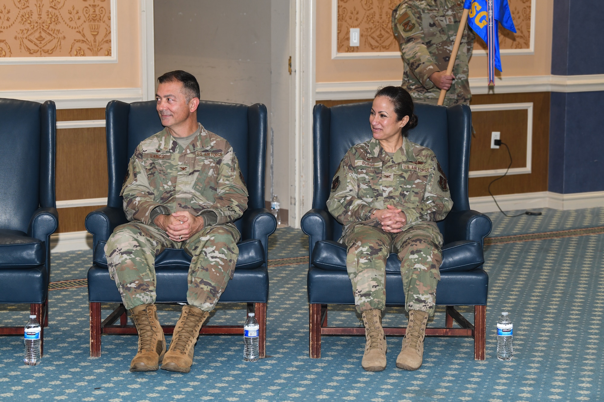 Two military members sitting in blue chairs.