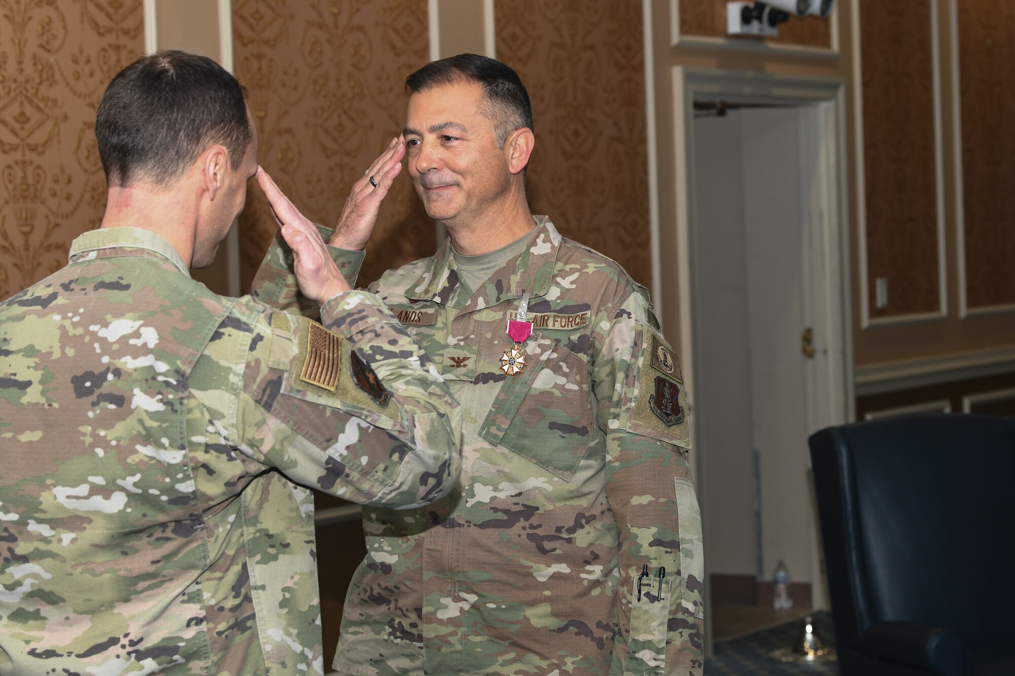 Two military members saluting each other.
