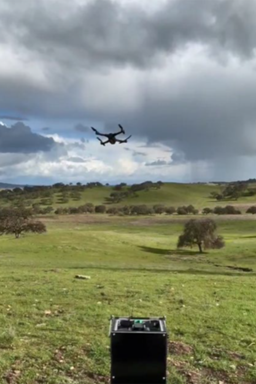 A military aircraft hovers over a field.