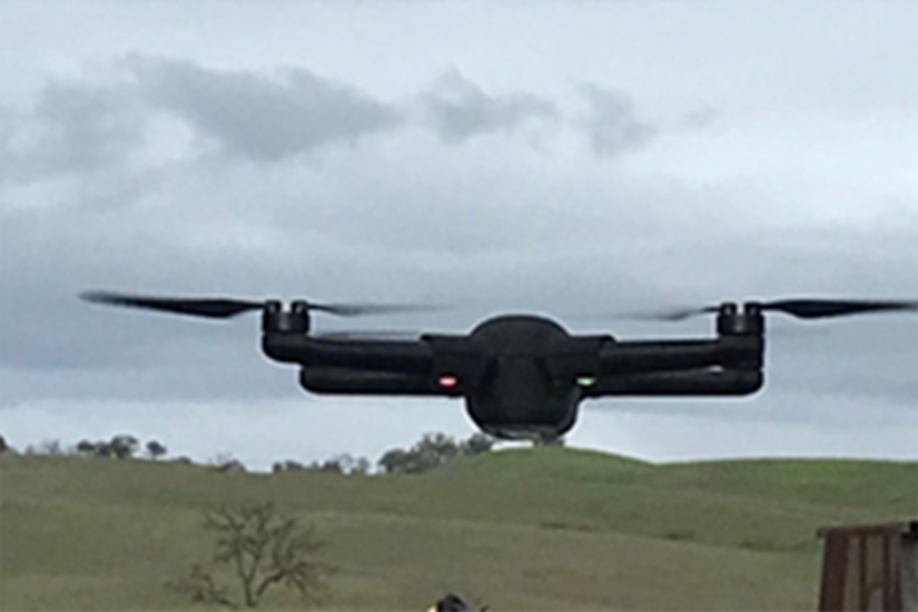 A military aircraft hovers over a field.