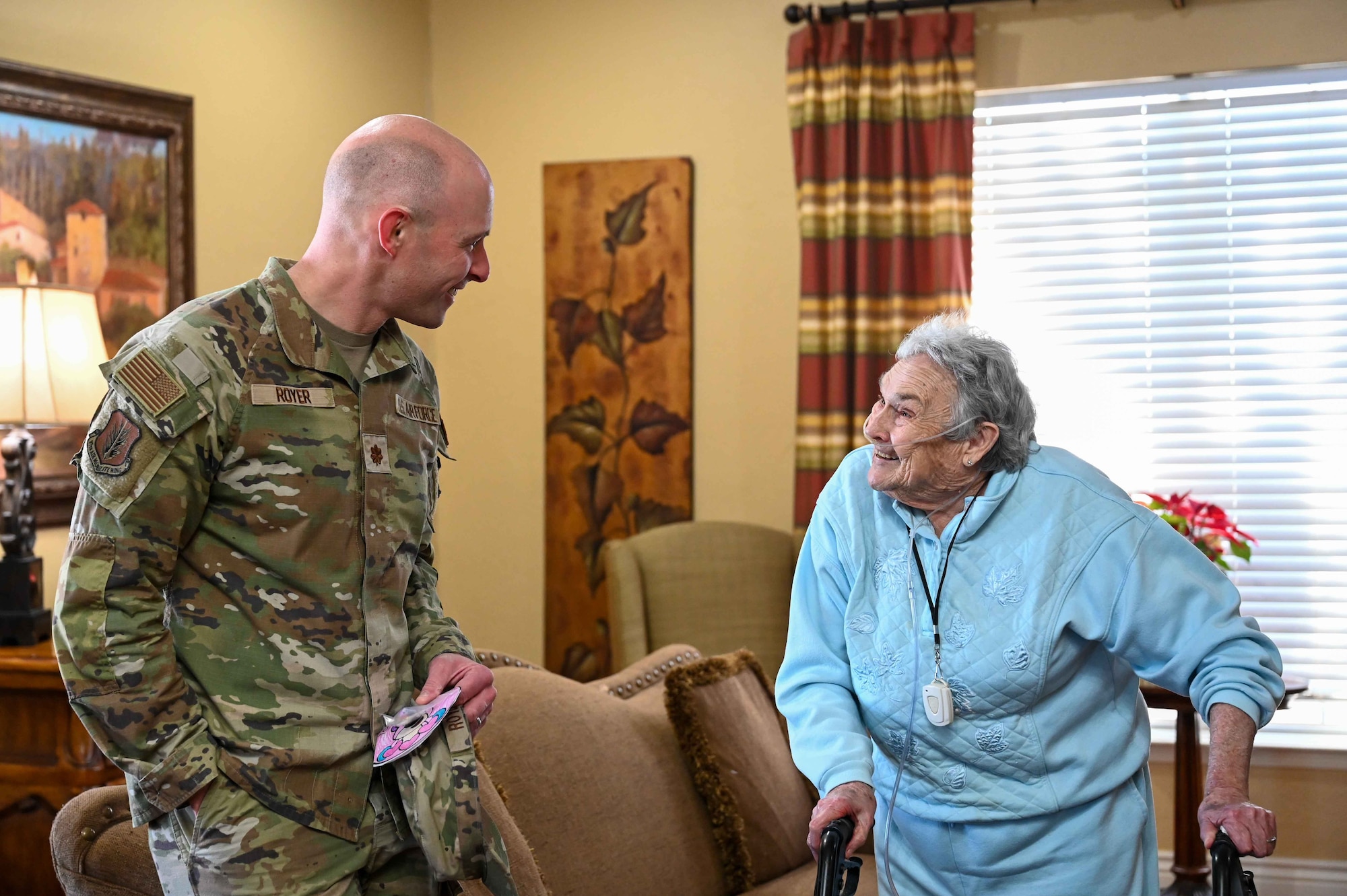 U.S. Air Force Maj. Nathan Royer, 97th Air Mobility Wing deputy staff judge advocate, talks with Eva M. Price, an Air Force veteran, at Tamarack Assisted Living in Altus, Oklahoma, Feb. 14,2024. Price served in the Air Force for two years in a communications squadron. (U.S. Air Force photo by Airman 1st Class Kari Degraffenreed)