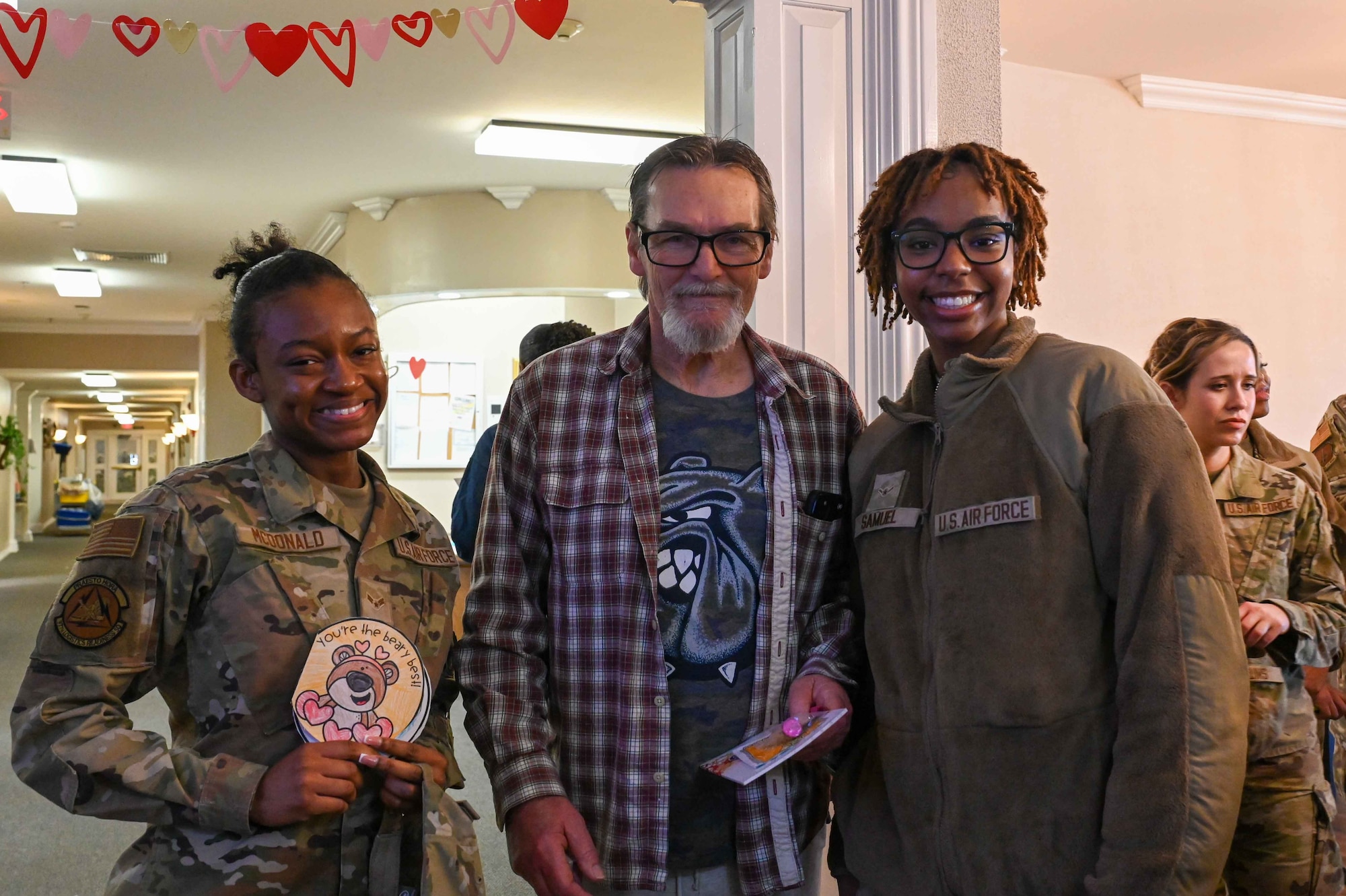 Bill Phillips, an Army veteran, poses for a photo with Airman 1st Class Jasmine McDonald, 97th Logistics Readiness Squadron central storage apprentice, and Airman Orieal Samuel, 97th Communications Squadron network infrastructure specialist, at Magnolia Creek in Altus, Oklahoma, Feb. 14, 2024. Phillips served in the Army for two years. (U.S. Air Force photo by Airman 1st Class Kari Degraffenreed)
