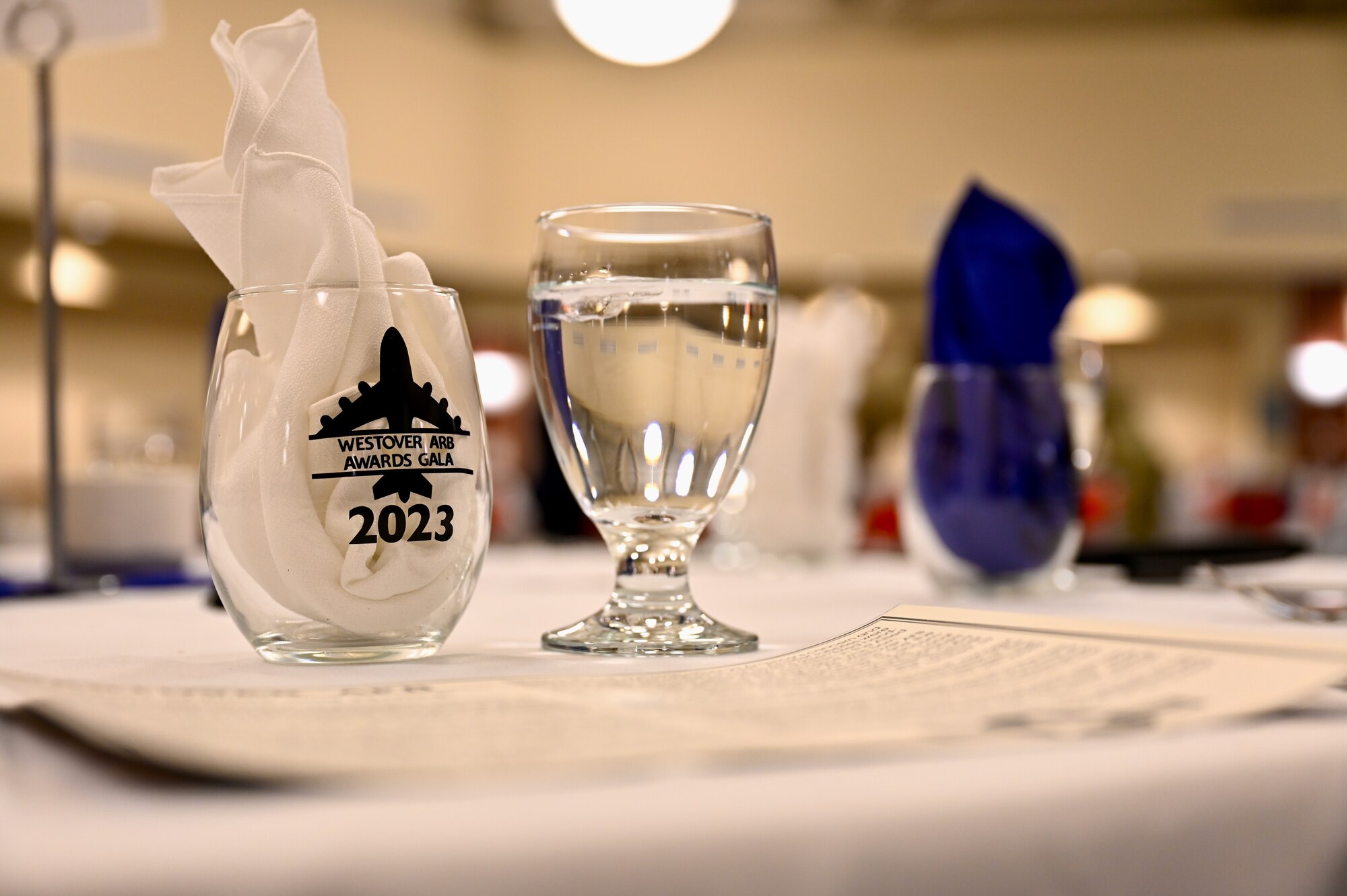 Place setting for a formal event, showing a wine glass with a folded napkin in it, and a glass of water.