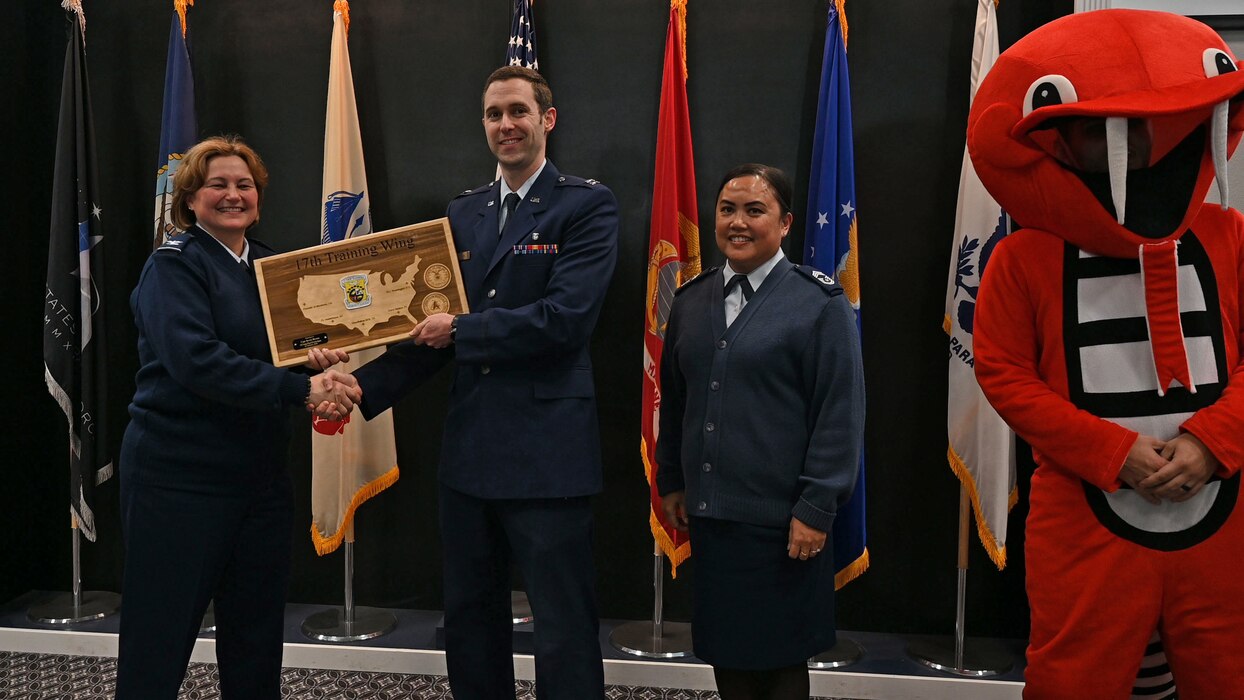 U.S. Air Force Capt. Kevin Brown, center, 17th Healthcare Operations Squadron pediatrician, receives the 17th Training Wing Company Grade Officer of the Quarter award from Col. Angelina Maguinness, left, 17th TRW commander, Chief Master Sgt. Catherine Gaco-Escalera, right, 17th MDG senior enlisted leader, and “Catharsis the Cobra,” far right, during the 17th TRW 4th Quarterly Awards Ceremony at the Powell Event Center, Goodfellow Air Force Base, Texas, Feb. 2, 2024. The 17th MDG oversees the treatment and care of all Goodfellow AFB personnel and their families. (U.S. Air Force photo by Airman 1st Class Evelyn J. D'Errico)