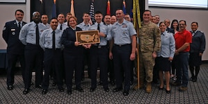 U.S. Air Force Staff Sgt. Luke Hopgood, center, 17 Force Support Squadron force management noncommissioned officer in charge, receives the 17th Training Wing Non-Commissioned Officer of the Quarter award from Col. Angelina Maguinness, left, 17th TRW commander, and Chief Master Sgt. Catherine Gaco-Escalera, right, 17th Medical Group senior enlisted leader, during the 17th TRW 4th Quarterly Awards Ceremony at the Powell Event Center, Goodfellow Air Force Base, Texas, Feb. 2, 2024. 17th FSS is responsible for programs covering military and civilian personnel, education services and family support for technical training students.   (U.S. Air Force photo by Airman 1st Class Evelyn J. D'Errico)