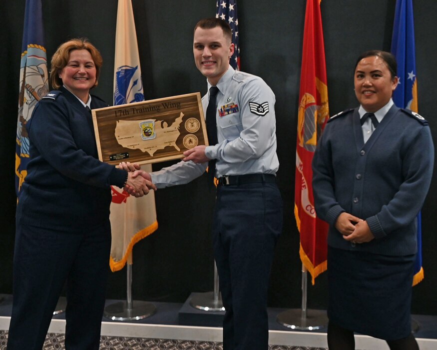 U.S. Air Force Staff Sgt. Luke Hopgood, center, 17 Force Support Squadron force management noncommissioned officer in charge, receives the 17th Training Wing Non-Commissioned Officer of the Quarter award from Col. Angelina Maguinness, left, 17th TRW commander, and Chief Master Sgt. Catherine Gaco-Escalera, right, 17th Medical Group senior enlisted leader, during the 17th TRW 4th Quarterly Awards Ceremony at the Powell Event Center, Goodfellow Air Force Base, Texas, Feb. 2, 2024. 17th FSS is responsible for programs covering military and civilian personnel, education services and family support for technical training students.   (U.S. Air Force photo by Airman 1st Class Evelyn J. D'Errico)