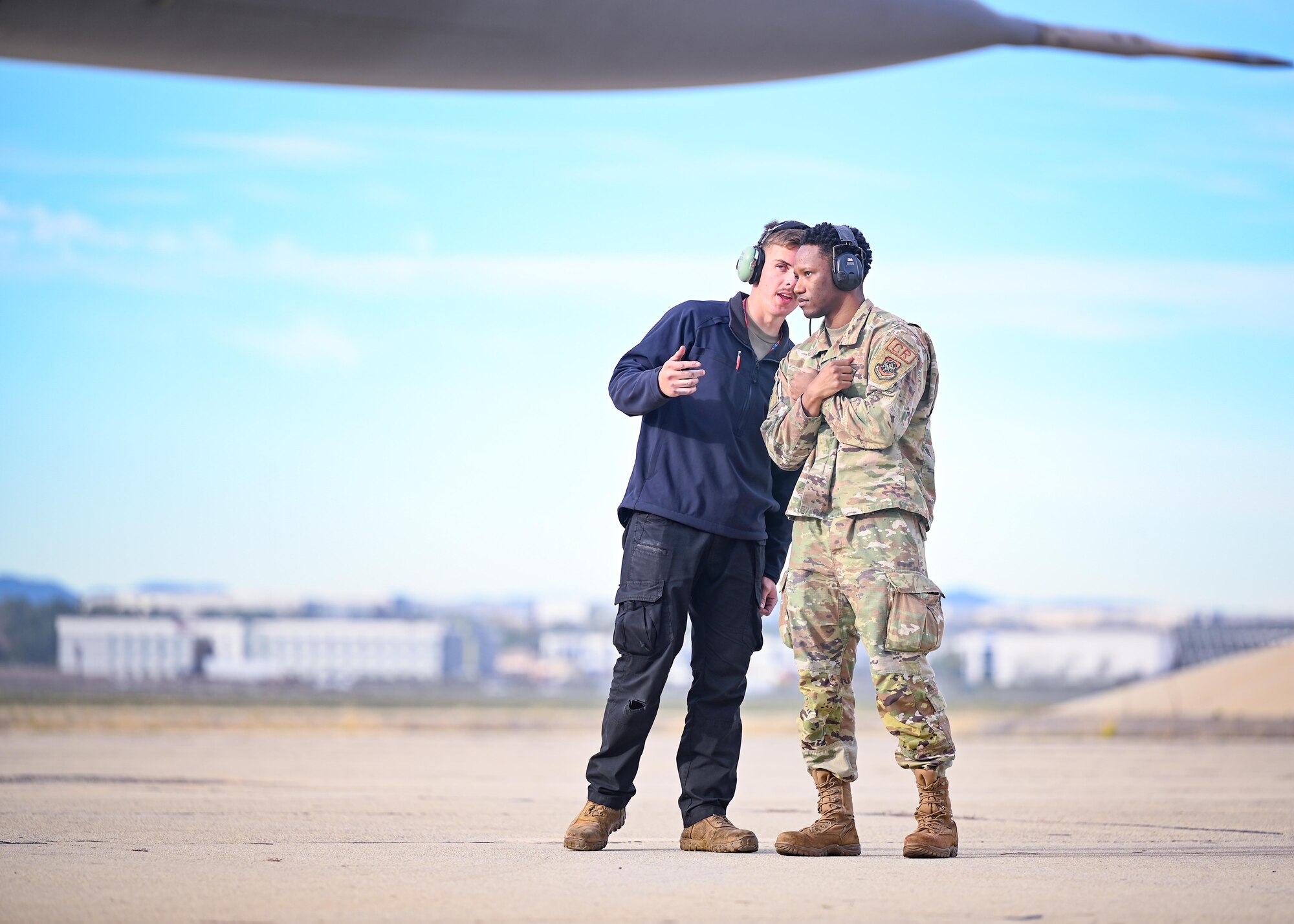 An Airman teaches another Airman how to marshal an aircraft.