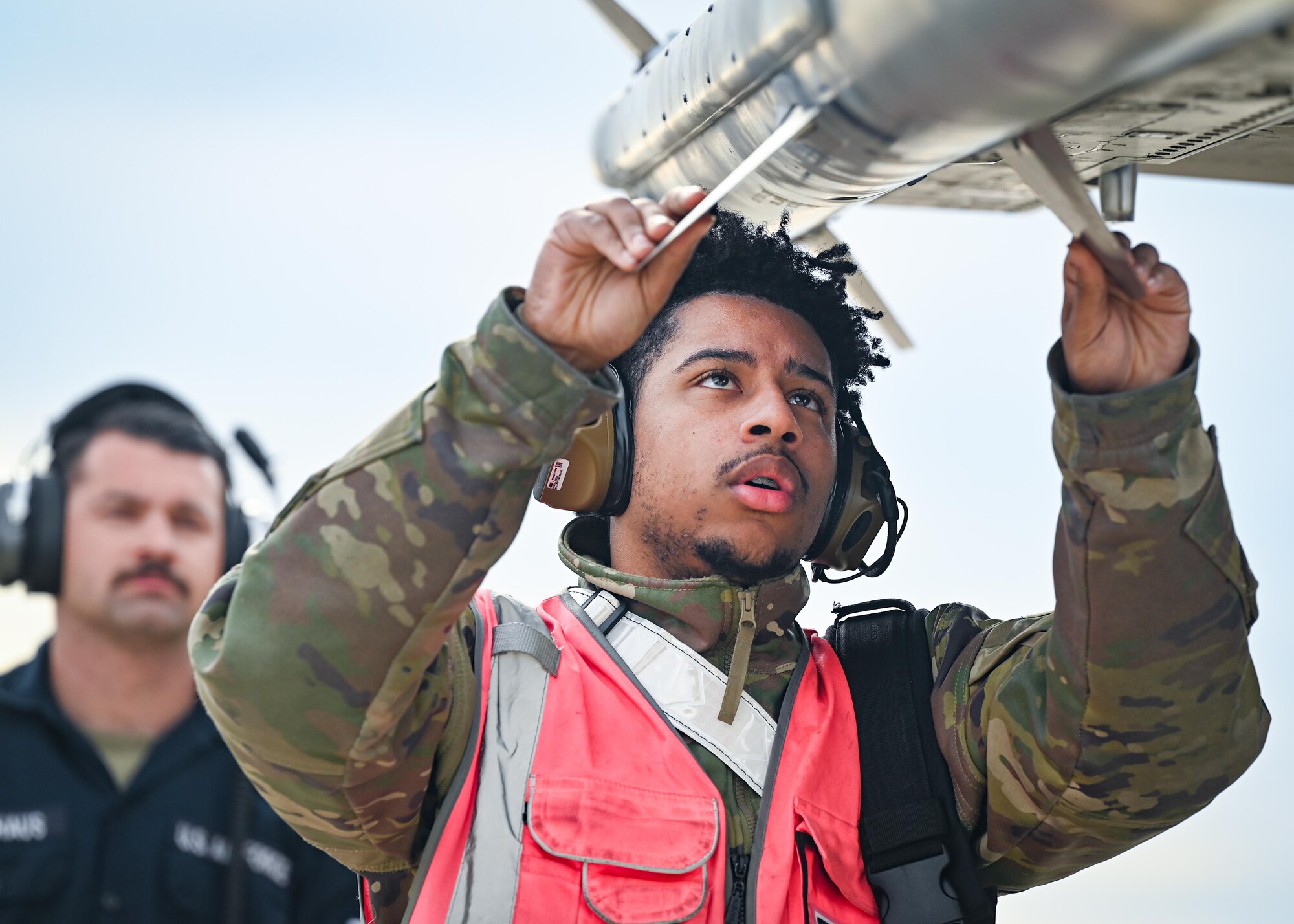 An Airman inspects munitions mounted to an aircraft.