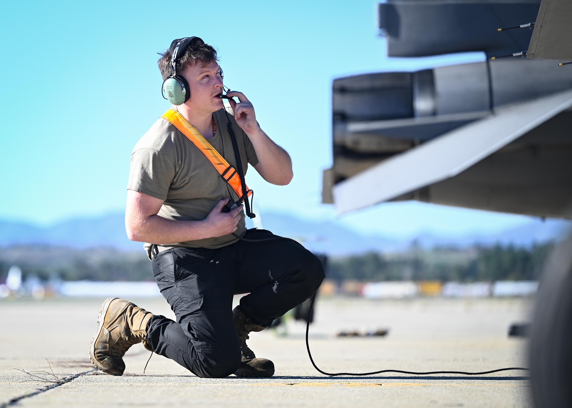 An Airman performs pre-flight checks on an aircraft.