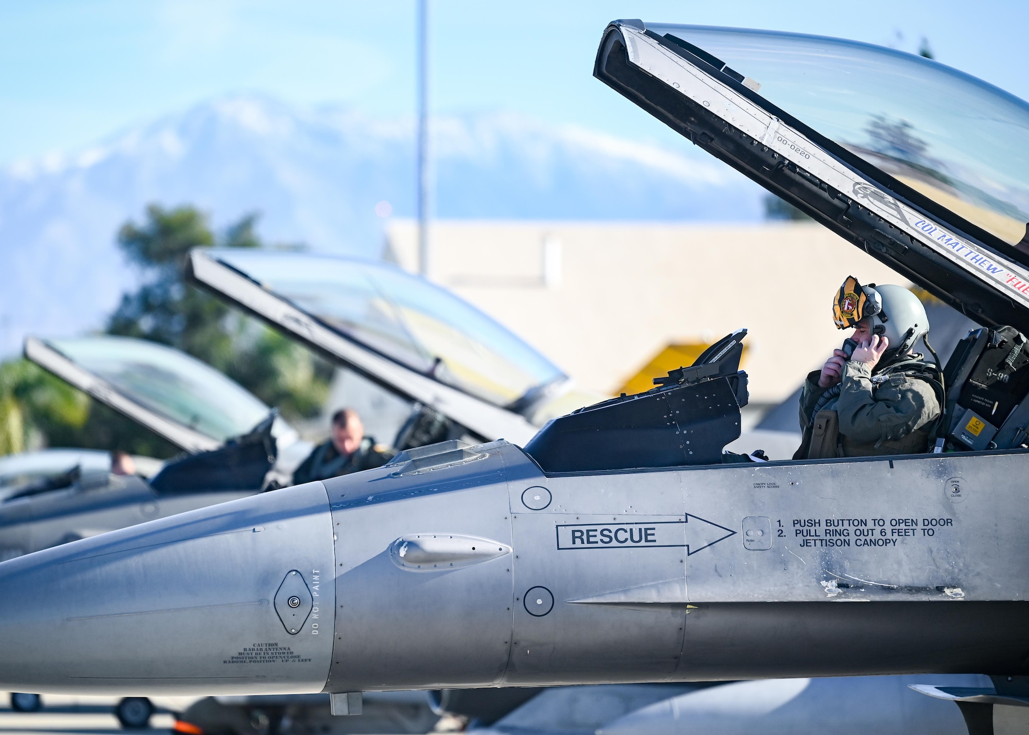 A pilot dons his helmet before takeoff.