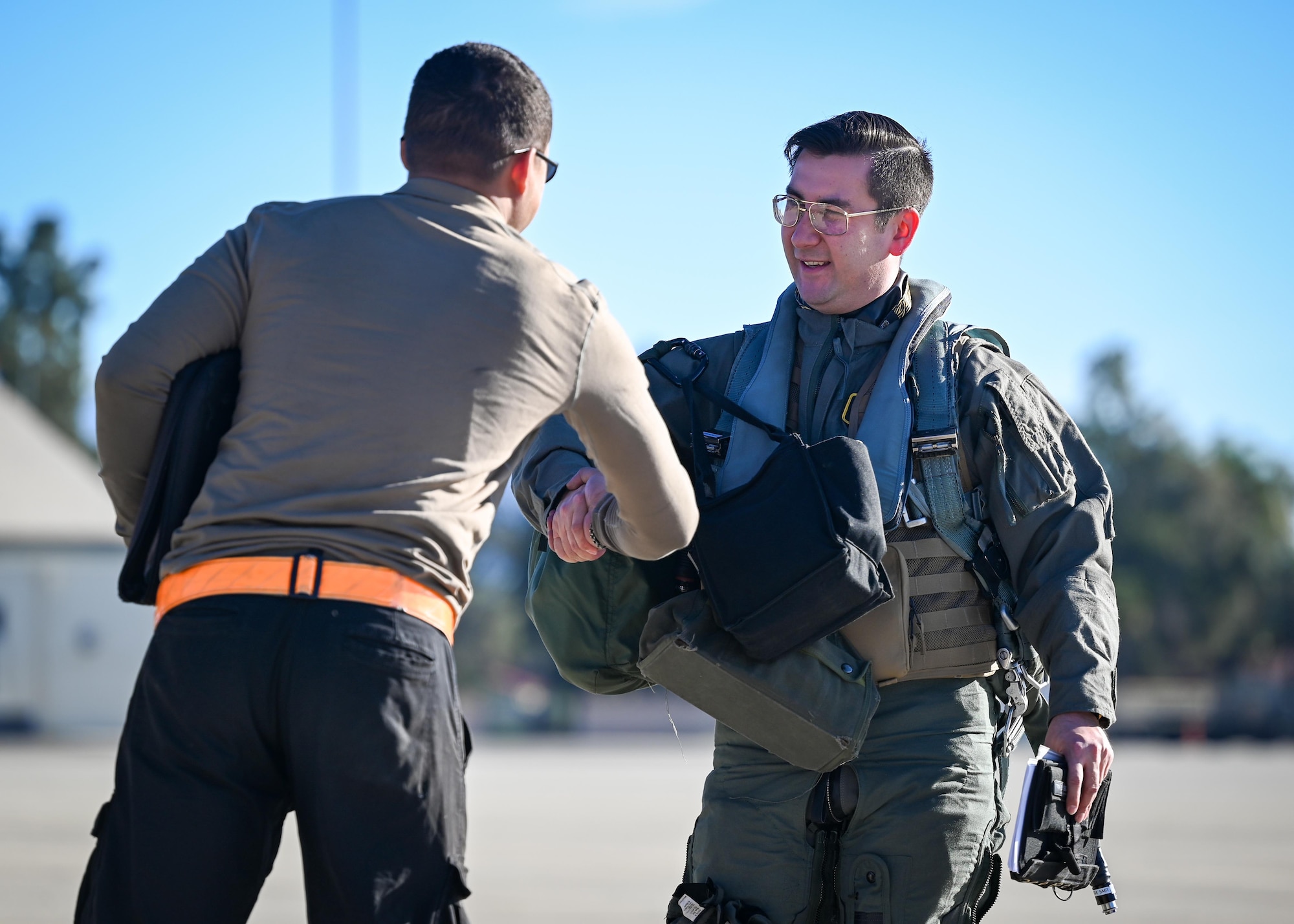 A maintenance Airman shakes hands with a pilot.