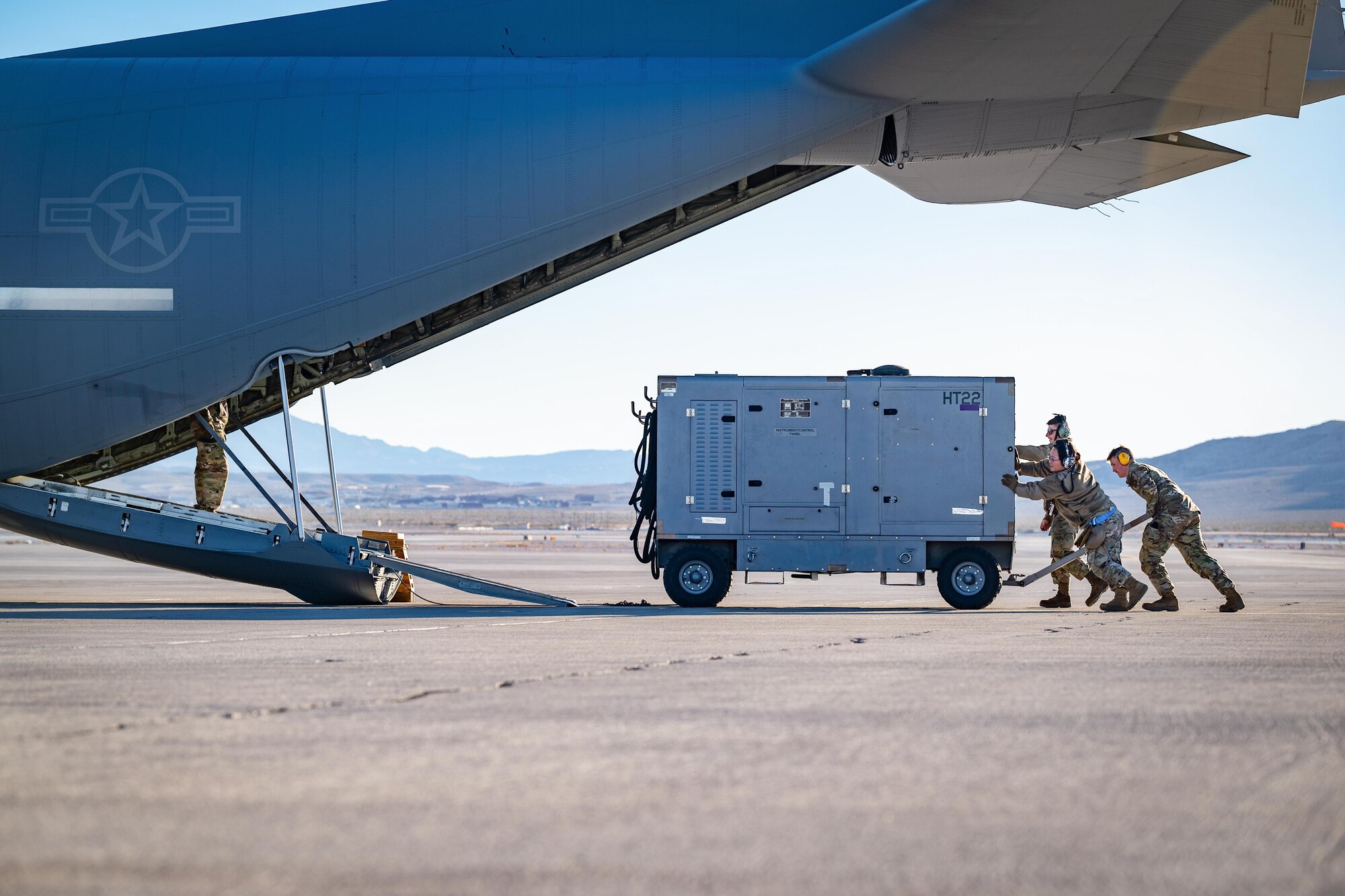 Airmen push cargo onto a C-130.
