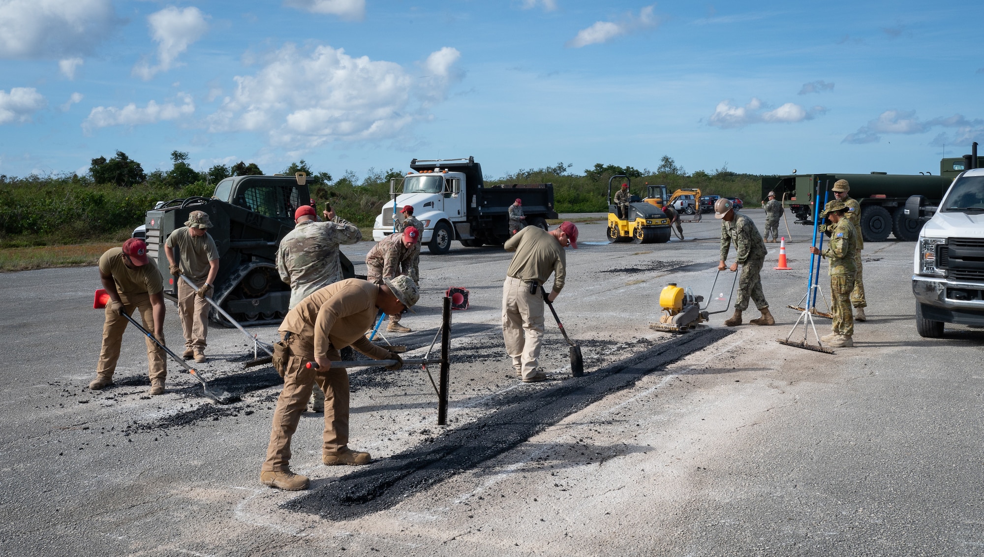 554th Rapid Engineering Deployable Heavy Operations Repair Squadron Engineer heavy equipment and pavement Airmen, U.S. Navy Sailors and Royal Australian Air Force members work together to repair Naval Base Guam's flight line, Feb. 8, 2024. During the annual Cope North exercise, partners from RAAF joined the 554th REDHORSE and NBG Sailors to rehabilitate the old flight line on Naval Base Guam. Their efforts are part of a larger plan to expand air power capabilities on Guam as simultaneous flight line revitalization efforts occur on Pacific Regional Training Center - Andersen, Guam. (U.S. Air Force photo by Staff Sgt. Pedro Tenorio)