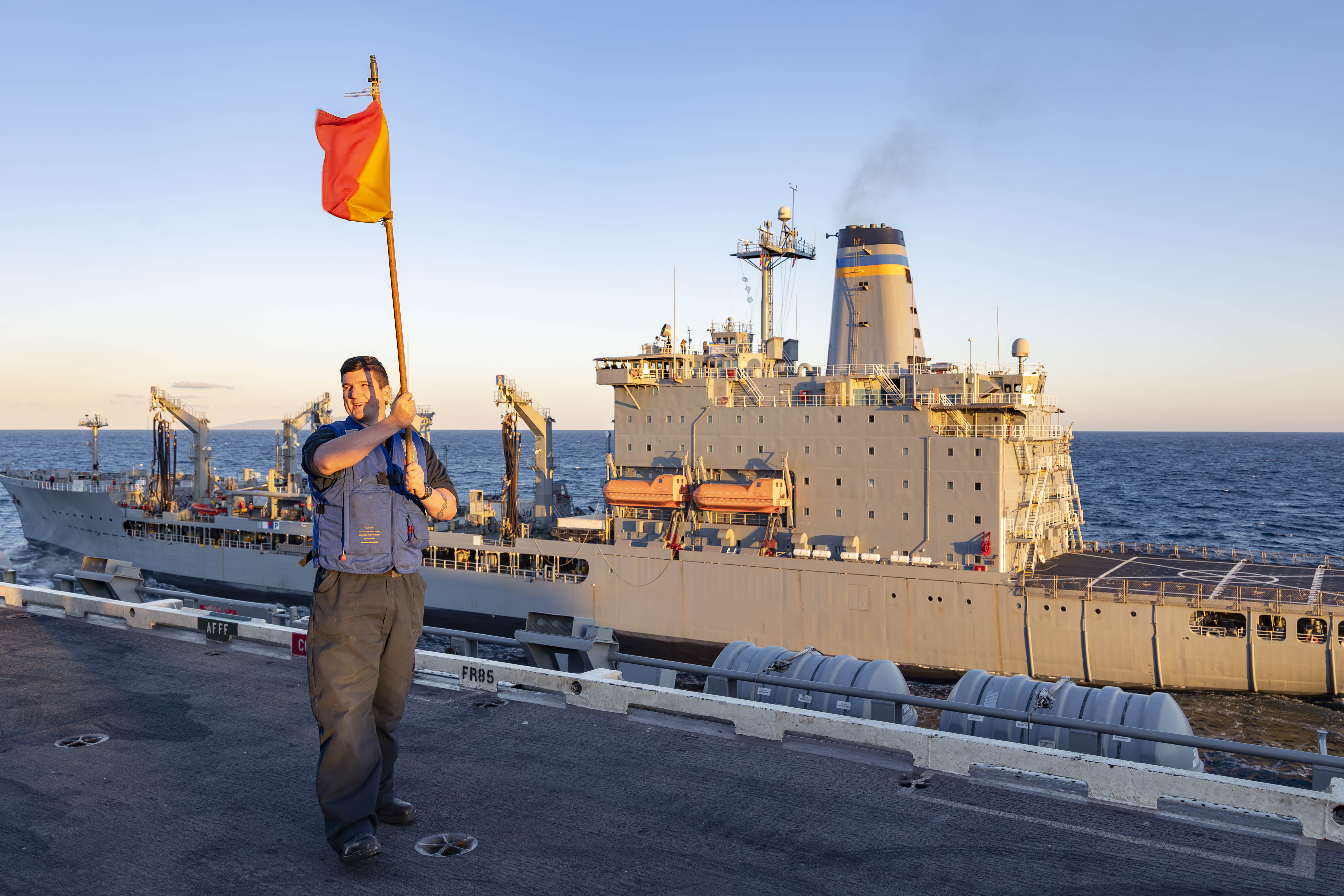QM2 Ethan Chapman signals to USNS Pecos (T-AO 197) from aboard  USS Abraham Lincoln (CVN 72).
