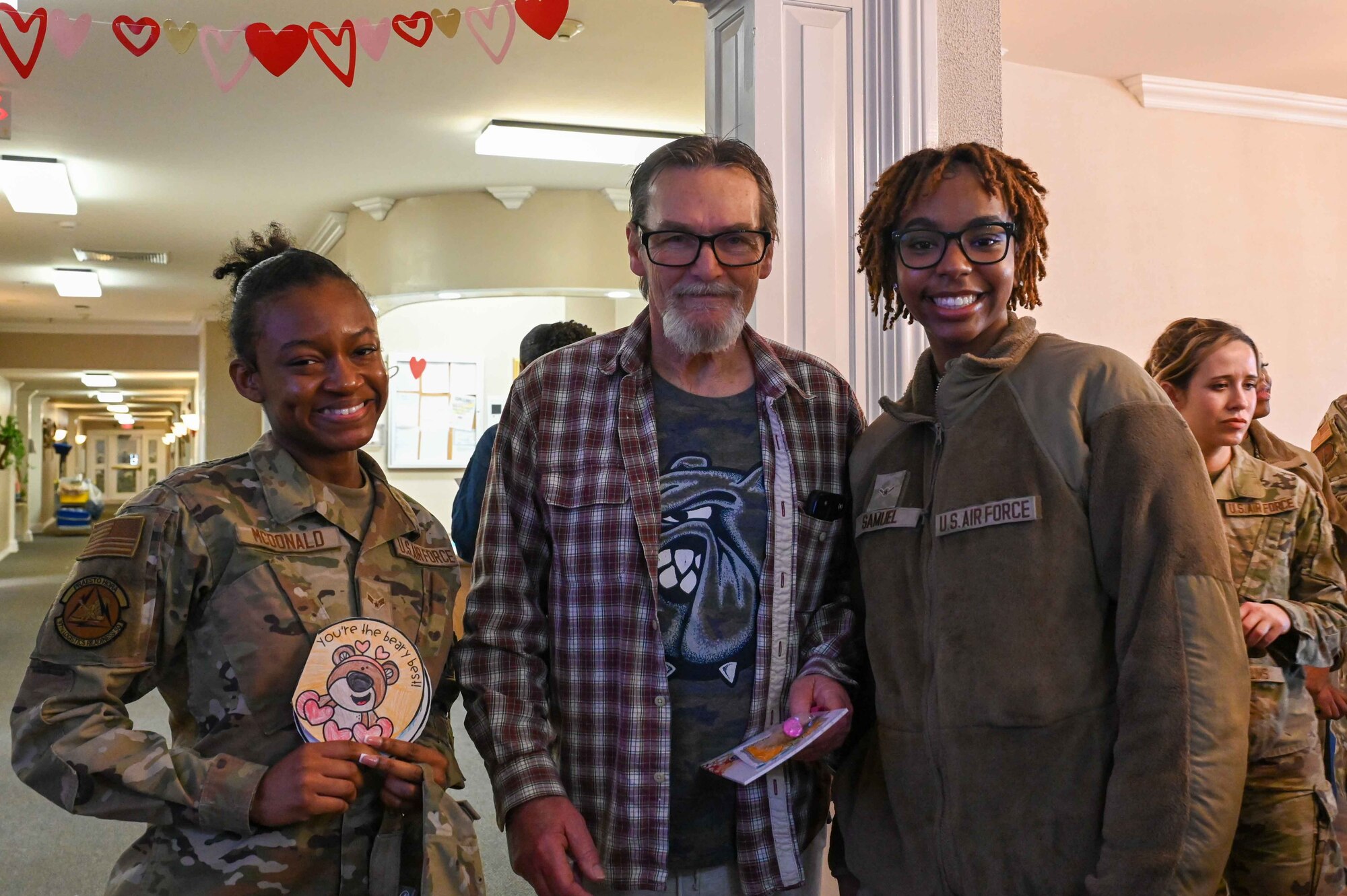 Bill Phillips, an Army veteran, poses for a photo with Airman 1st Class Jasmine McDonald, 97th Logistics Readiness Squadron central storage apprentice, and Airman Orieal Samuel, 97th Communications Squadron network infrastructure specialist, at Magnolia Creek in Altus, Oklahoma, Feb. 14, 2024. Phillips served in the Army for two years. (U.S. Air Force photo by Airman 1st Class Kari Degraffenreed)