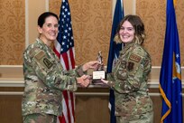 A general and Airman holding a trophy