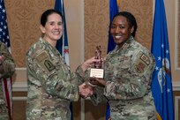 A general and Airman holding a trophy