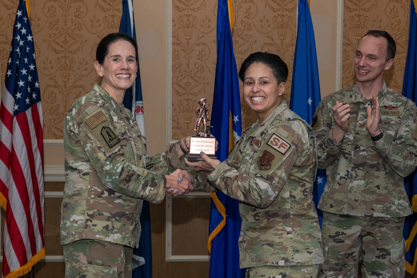 A general and Airman holding a trophy