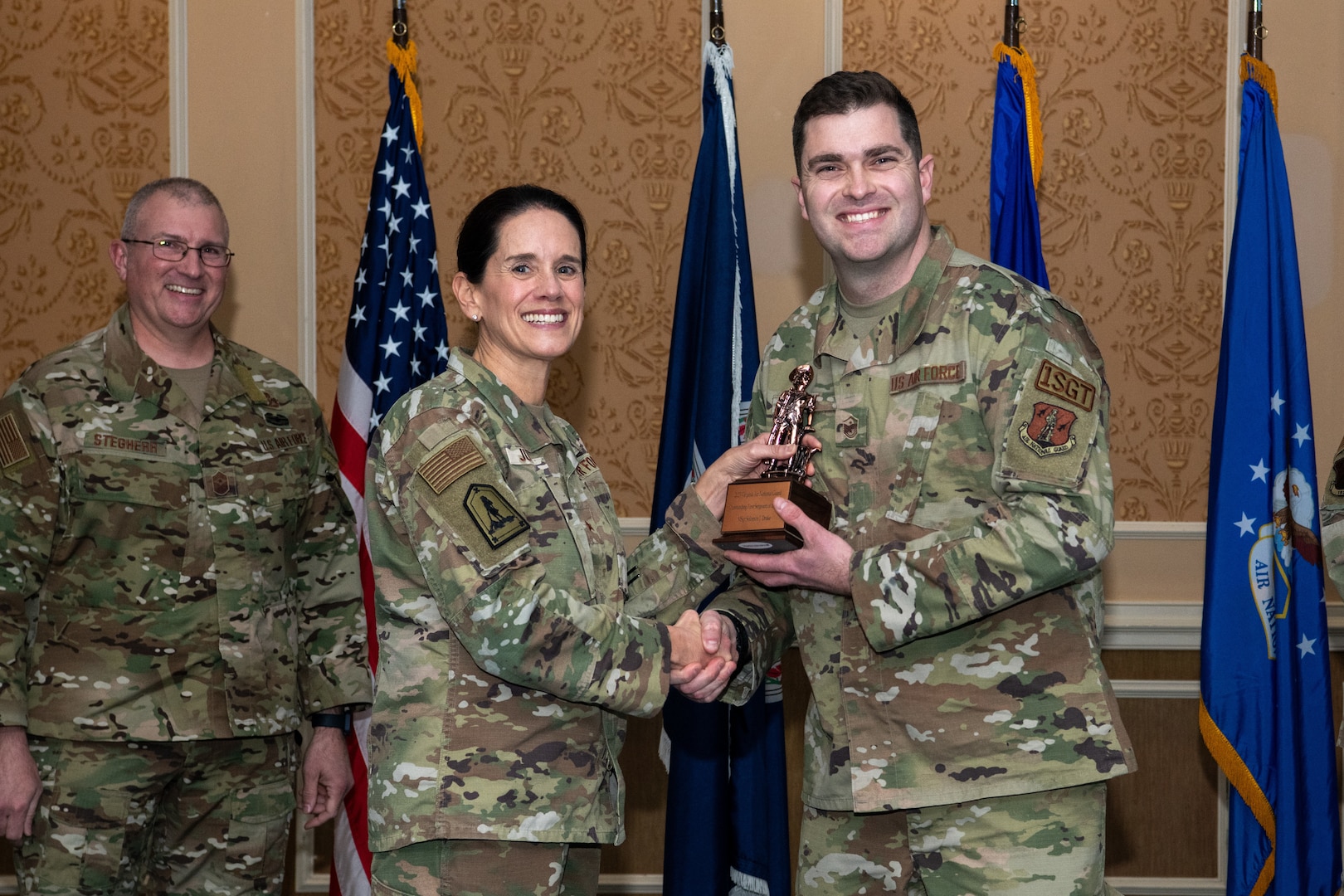 A general and Airman holding a trophy