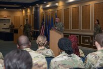 Military member at podium talking to audience of Airmen.