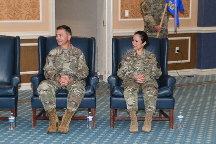 Two military members sitting in blue chairs.