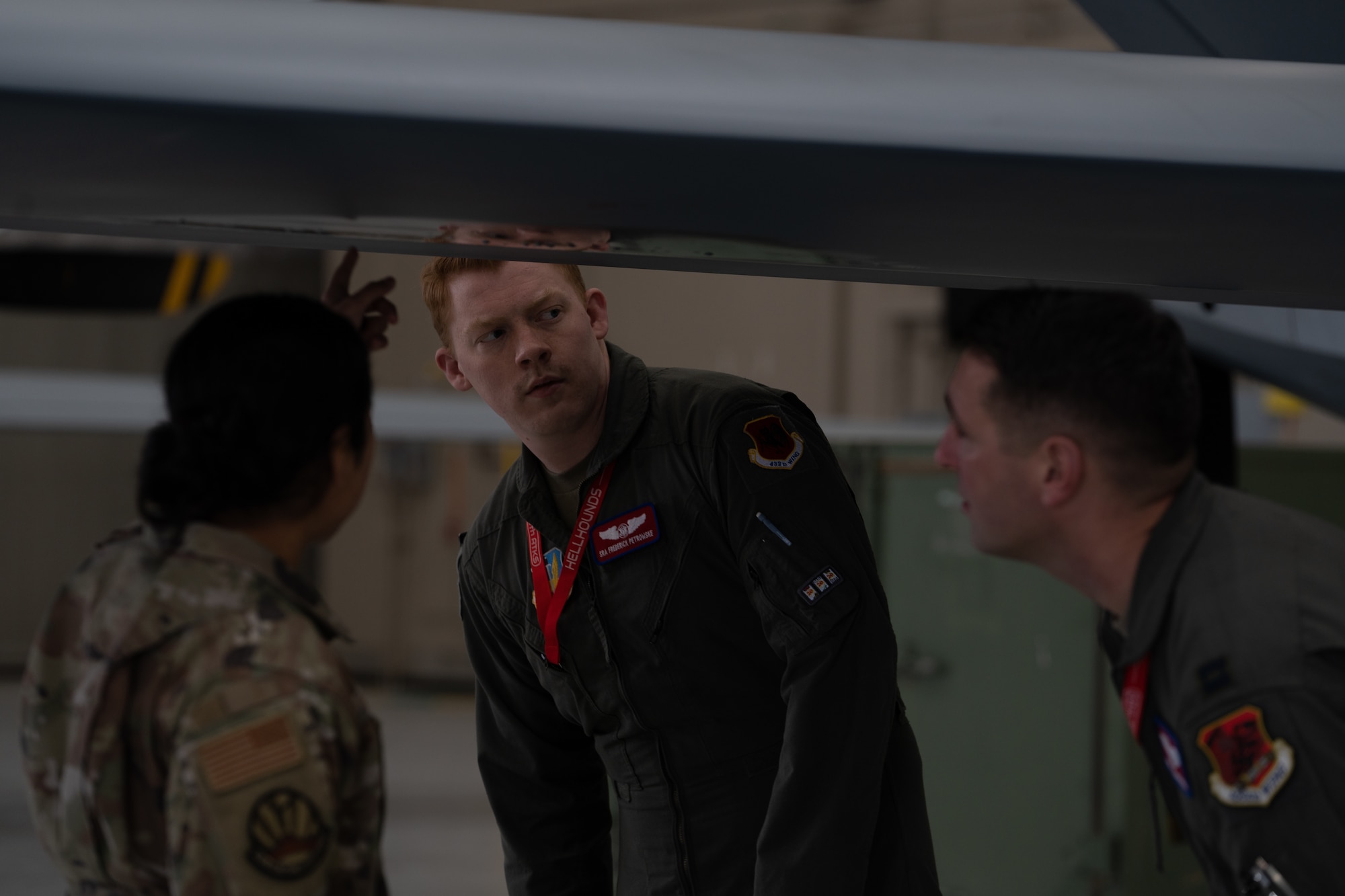 A man in a flight suit examines a remotely piloted aircraft.