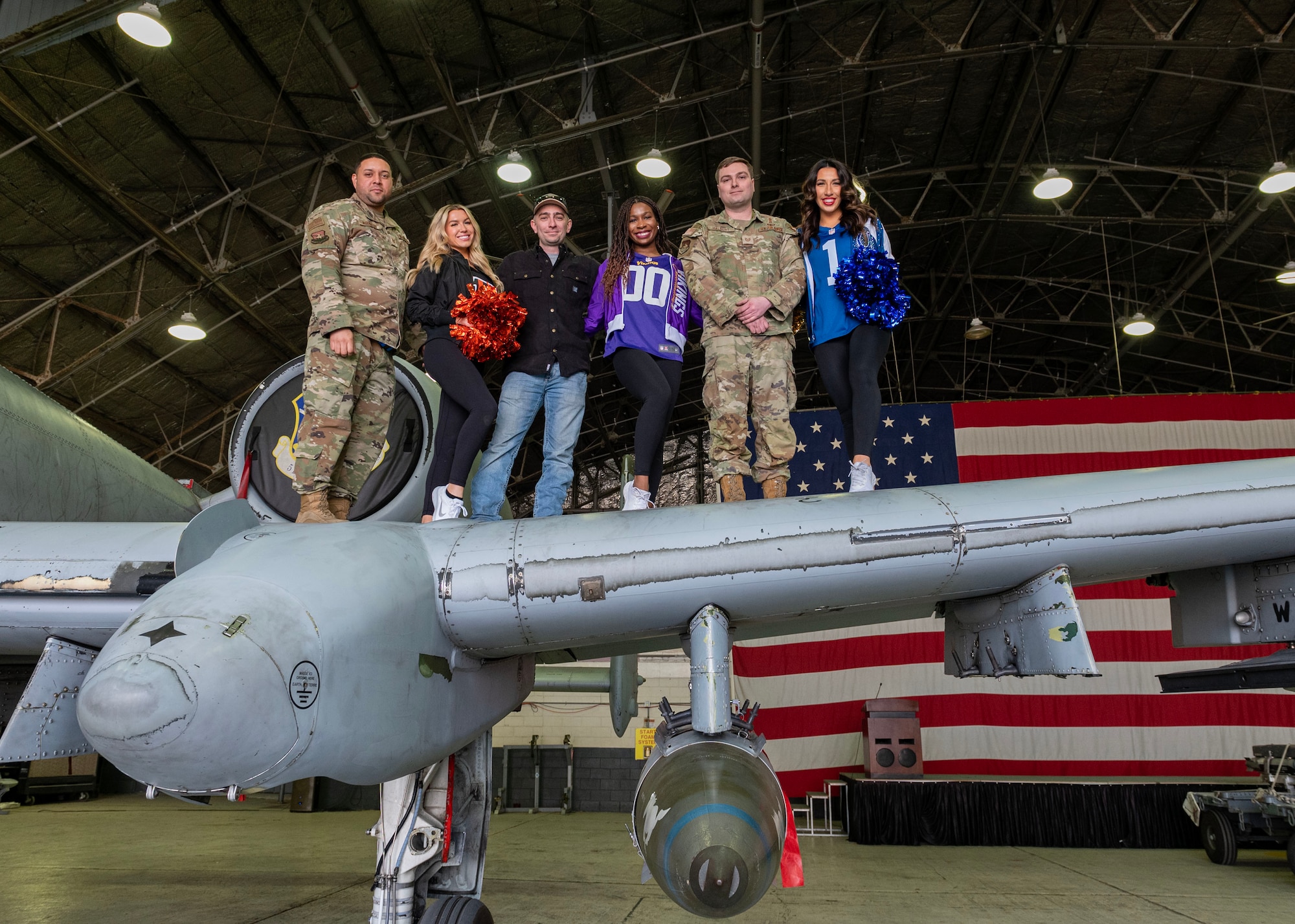 U.S. Airmen assigned to the 51st Maintenance Group take a group photo with NFL cheerleaders during the Pro Blitz 2024 unit visit at Osan Air Base, Republic of Korea, Feb. 10, 2024. The cheerleaders' visit was part of the NFL tour sponsored by the Armed Forces Entertainment. (U.S. Air Force photo by Staff Sgt. Aubree Owens)