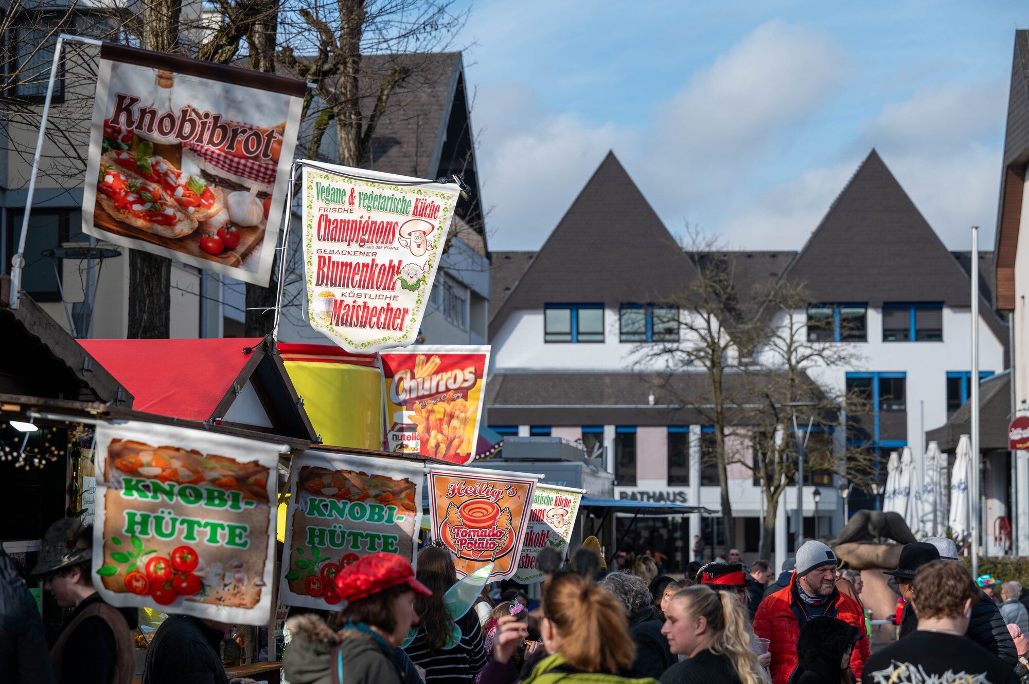 People purchase food from vendors on the street in front of the Rathaus (city hall)