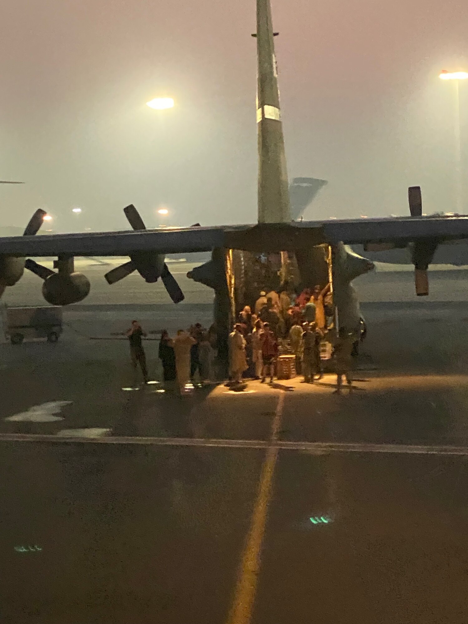 Afghan refugees depart from a C-130H Hercules during Operation Allies Refuge in August of 2021 at Al Udeid Air Base, Qatar. Twenty-three McConnell Airmen received Air Medal-Combat Devices for their participation in the evacuation. (Courtesy Photo)